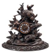 A Black Forest carved walnut mantel clock: the French eight-day duration movement striking the