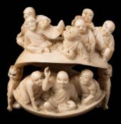 A large Japanese carved ivory netsuke of a clam: with monks in the interior and exterior,