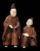 A Japanese boxwood and ivory okimono of entertainers,