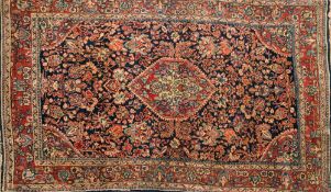 A Meshed rug:, the indigo field with a central red hexagonal pole medallion,