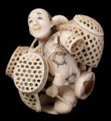 A Japanese carved and stained ivory okimono of a basket seller,