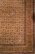 A Sivas carpet:, the beige field with an all over geometric palmette, medallion and leaf design,