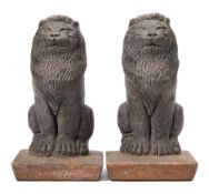 A pair of pottery seated lion finials: mounted on square tapering bases 35cm. high.