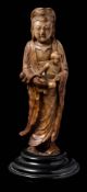A Chinese carved soapstone figure of Guanyin: with chignon-tied upswept hair and wearing loose