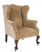 A carved mahogany wing frame armchair in the Georgian taste:, fully upholstered, on cabriole legs,
