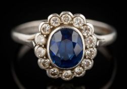 A sapphire and diamond oval cluster ring: the oval sapphire approximately 7.5mm long x 6.
