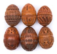 A collection of six carved egg-shaped coquilla nut pomanders: with concentric ringed,
