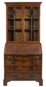 A George III mahogany bureau bookcase:, of small size, the upper part with a moulded cornice,