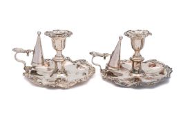 A pair of silver plated chambersticks: with urn-shaped nozzles and scroll borders,
