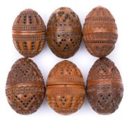 A collection of six carved egg-shaped coquilla nut pomanders: with concentric ringed,