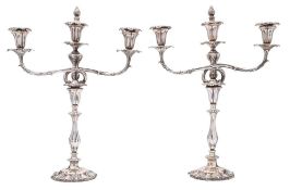 A pair of Victorian silver plated twin-branch candelabra: the urn shaped nozzles with foliate