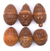 A collection of six carved egg-shaped coquilla nut pomanders: with concentric ringed,