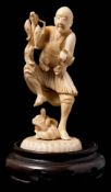 A Japanese carved ivory okimono of a fisherman: urprised by a snake emerging from a rock,