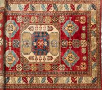 A Kasak rug:, the square ivory central field with hooked motifs,