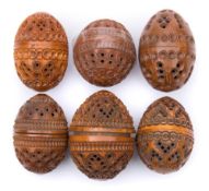A collection of six carved egg-shaped coquilla nut pomanders: with concentric ringed,