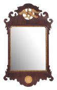 A 19th Century mahogany and partly gilt fret cut mirror:, surmounted by a figure of a Ho-Ho bird,