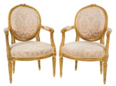 A set of four carved giltwood fauteuils:, in the Louis XV/XVI transitional taste,
