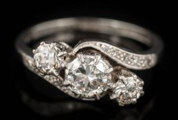 An early 20th century diamond three-stone cross-over ring: with graduated,