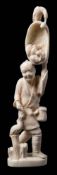 A Japanese carved ivory okimono: of a cormorant fisherman holding a large net of fish above his