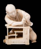 A Japanese carved ivory okimono of a carpenter,