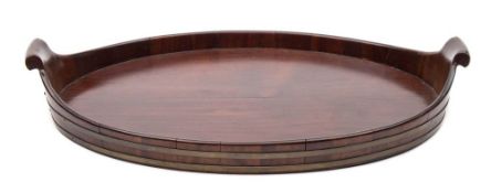 An 18th century mahogany and brass bound oval twin handled tray: with scroll handles to the sides,