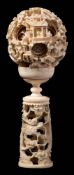 A Canton carved and pierced ivory puzzle ball and stand: of traditional form with ten graduated