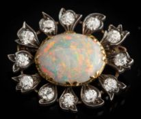 An opal and diamond mounted oval cluster flower brooch: with central oval opal approximately 17mm x