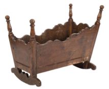An 18th Century oak cradle:, of rectangular shape with tapered and serpentine topped sides,