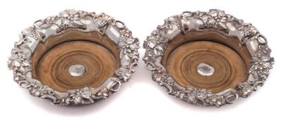 A pair of silver plated wine coasters: of circular outline with grape and vine leaf decorated