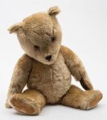A blonde plush Teddy bear:, with glass eyes ,