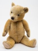 A golden plush Teddy bear:, with glass eyes,