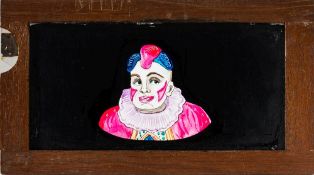 A magic lantern slipping side of a clown with moving eyes:, unsigned, in a mahogany frame.