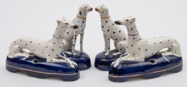 Two pairs of Staffordshire pottery Dalmatian ink wells: one pair recumbent,