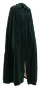 A Quad green velvet cape:, with quilted lining and black frogging to collar,