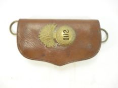A brown leather cartridge pouch with a British Indian 102nd Royal Madras Fusilier's glengarry badge