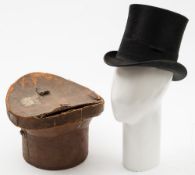 A black felt top hat by Christys London in a brown leather hat box: (damaged) size 61/2,