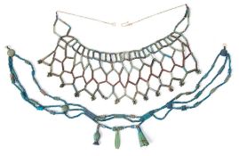 A bright blue glazed bead necklace with attached amulets, together with one other necklace,