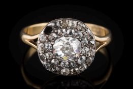 A diamond mounted round cluster ring: with a central oval,