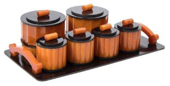 An Art Deco period nine piece orange and black bakelite dressing table set: includes scent bottle,
