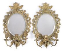 A pair of brass Girandole mirrors: with oval bevelled mirror plates,