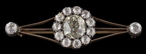 A late 19th century gold and diamond bar brooch: the central cushion-shaped old,