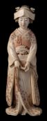 An early 20th century Japanese ivory okimono of a Geisha: wearing traditional floral decorated