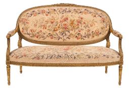 A French carved giltwood and tapestry canape in the Louis XV/XVI transitional taste:, the oval back,