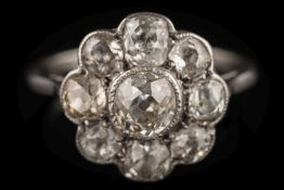 A diamond mounted circular cluster ring: with central round old brilliant-cut diamond approximately