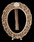 A late 19th century Continental ivory oval frame: carved with a vacant cartouche within a