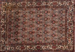 An Afshar rug:, the beige field with a repeated geometric floral design,