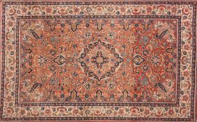 A pair of Kashan rugs:, the brick red fields each with an indigo cartouche pole medallion,