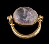 A carved amethyst scarab mounted swivel ring: in the Egyptian style, 8.5gms gross weight.