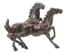 A Chinese bronze group of two horses: cantering side by side, unsigned, 17cm. long.