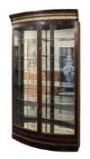 A large Edwardian stained mahogany bow-fronted shop display cabinet:,